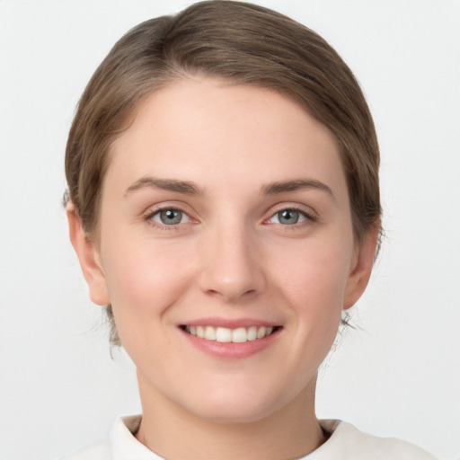 Joyful white young-adult female with medium  brown hair and grey eyes