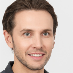 Joyful white young-adult male with short  brown hair and grey eyes