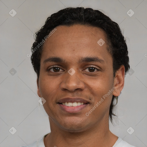 Joyful black young-adult male with short  black hair and brown eyes