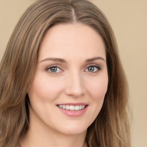 Joyful white young-adult female with long  brown hair and green eyes