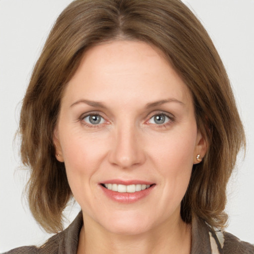 Joyful white young-adult female with medium  brown hair and grey eyes