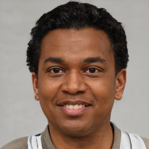 Joyful latino young-adult male with short  black hair and brown eyes