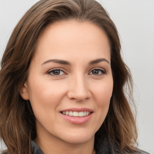 Joyful white young-adult female with long  brown hair and brown eyes