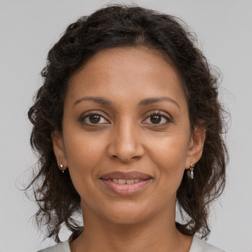 Joyful black young-adult female with medium  brown hair and brown eyes