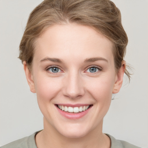 Joyful white young-adult female with short  brown hair and grey eyes