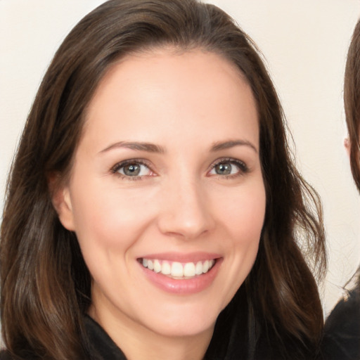 Joyful white young-adult female with long  brown hair and brown eyes