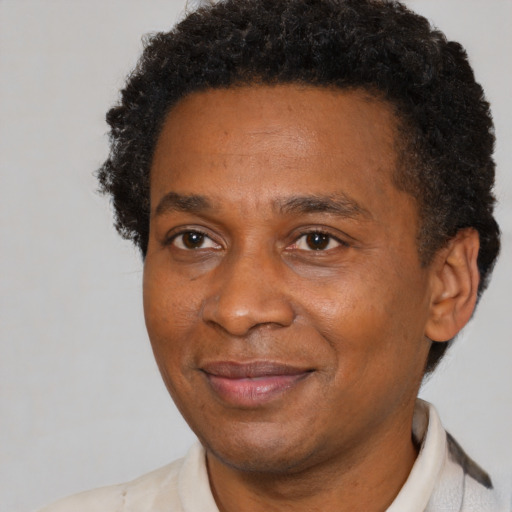 Joyful black adult male with short  brown hair and brown eyes