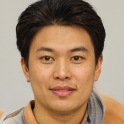 Joyful asian young-adult male with short  brown hair and brown eyes