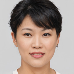 Joyful asian young-adult female with short  brown hair and brown eyes