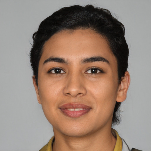 Joyful latino young-adult female with short  black hair and brown eyes