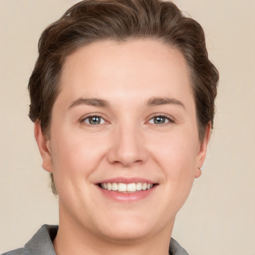 Joyful white young-adult female with short  brown hair and grey eyes