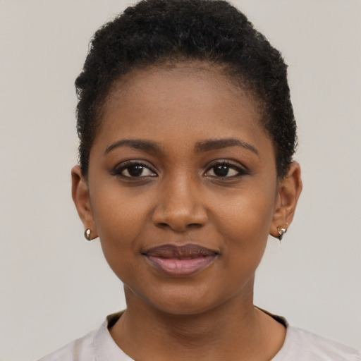 Joyful black young-adult female with short  black hair and brown eyes