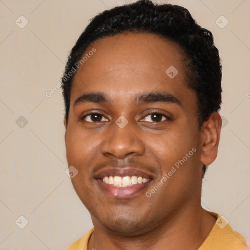 Joyful black young-adult male with short  black hair and brown eyes