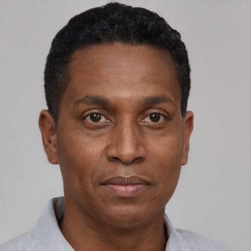 Joyful black adult male with short  black hair and brown eyes