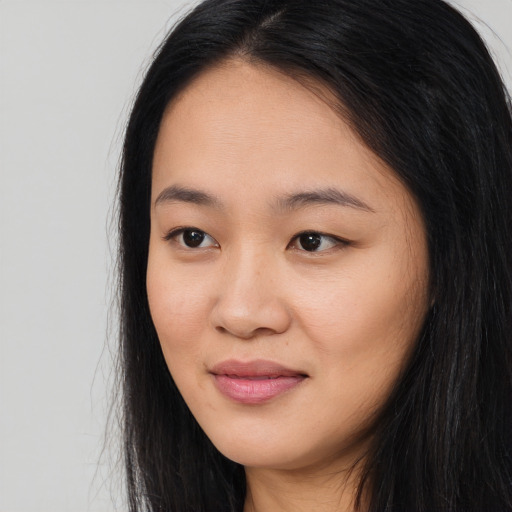 Joyful asian young-adult female with long  brown hair and brown eyes