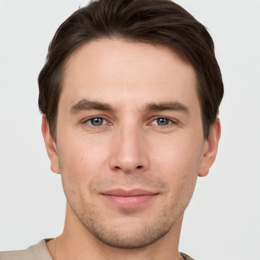 Joyful white young-adult male with short  brown hair and grey eyes