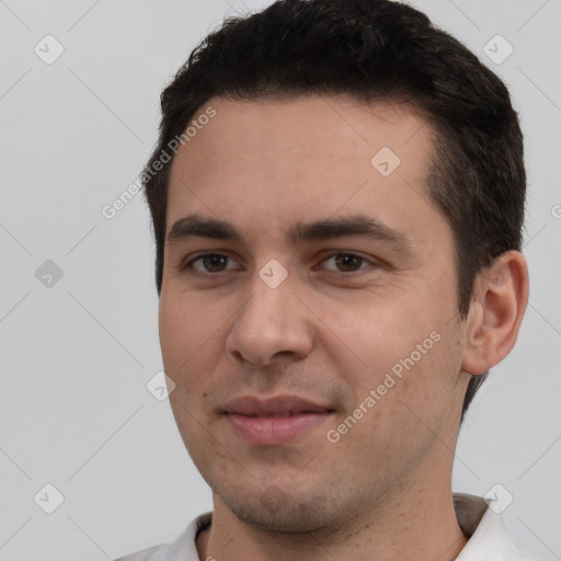 Joyful white young-adult male with short  black hair and brown eyes