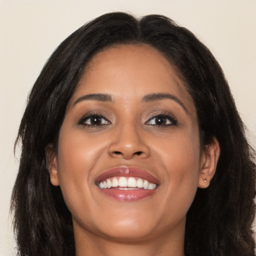 Joyful latino young-adult female with long  brown hair and brown eyes