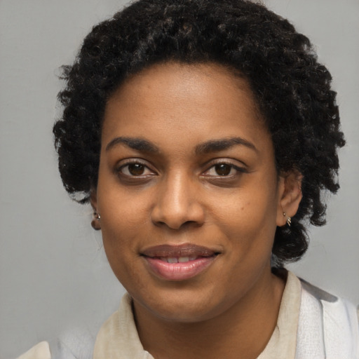 Joyful black young-adult female with short  black hair and brown eyes