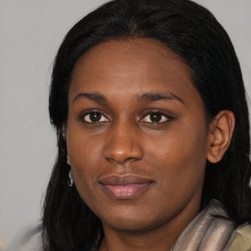 Joyful black young-adult female with long  black hair and brown eyes