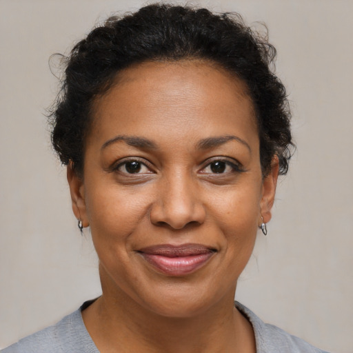 Joyful black adult female with short  brown hair and brown eyes