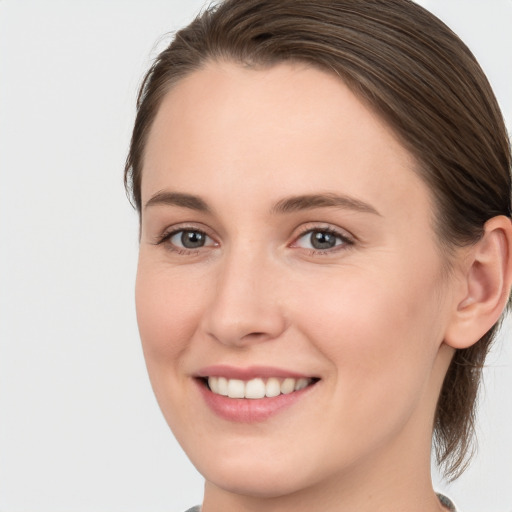 Joyful white young-adult female with long  brown hair and grey eyes