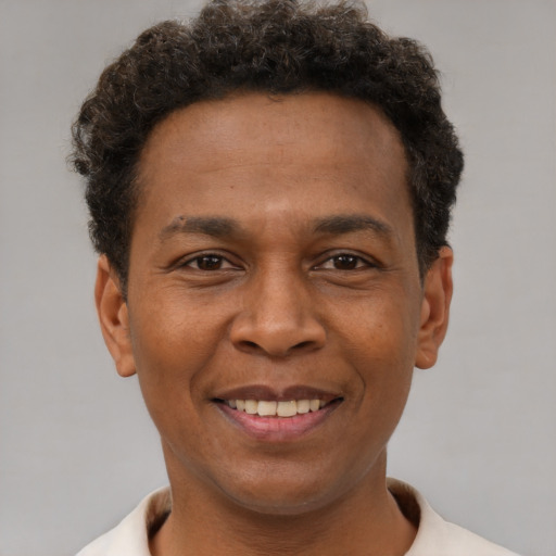 Joyful black young-adult male with short  brown hair and brown eyes