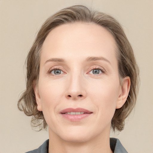 Joyful white adult female with medium  brown hair and grey eyes