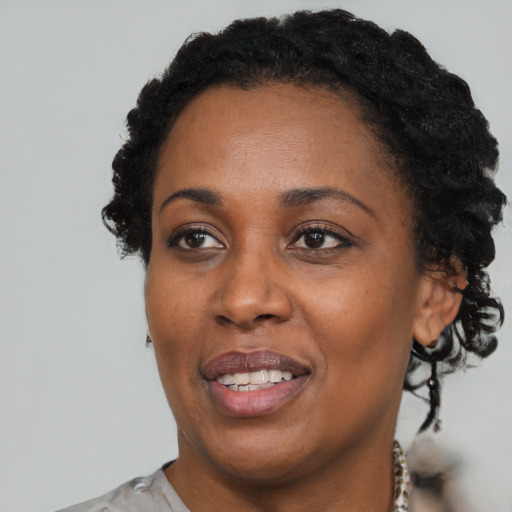 Joyful black adult female with short  black hair and brown eyes