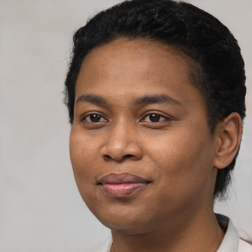 Joyful black young-adult female with short  black hair and brown eyes