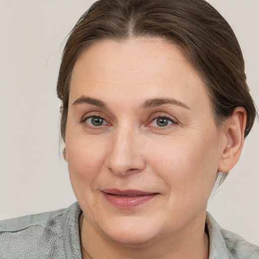 Joyful white adult female with medium  brown hair and grey eyes