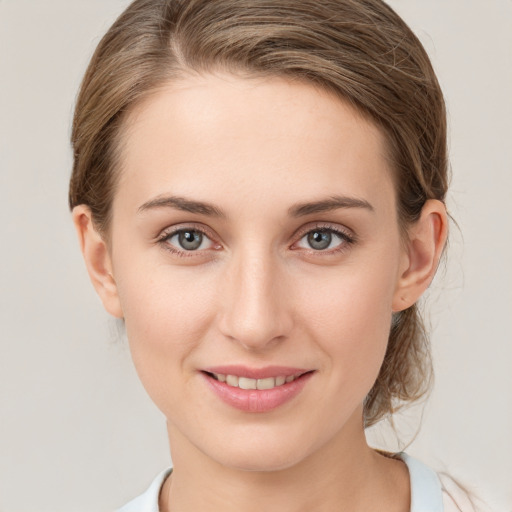 Joyful white young-adult female with medium  brown hair and grey eyes