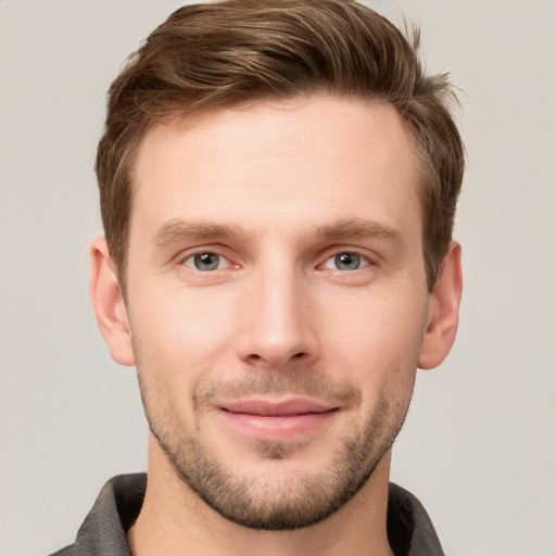 Joyful white young-adult male with short  brown hair and grey eyes