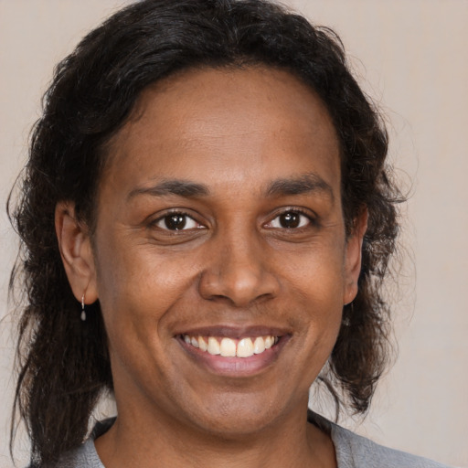 Joyful black adult female with medium  brown hair and brown eyes