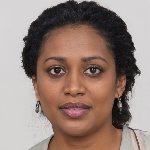 Joyful black young-adult female with long  black hair and brown eyes
