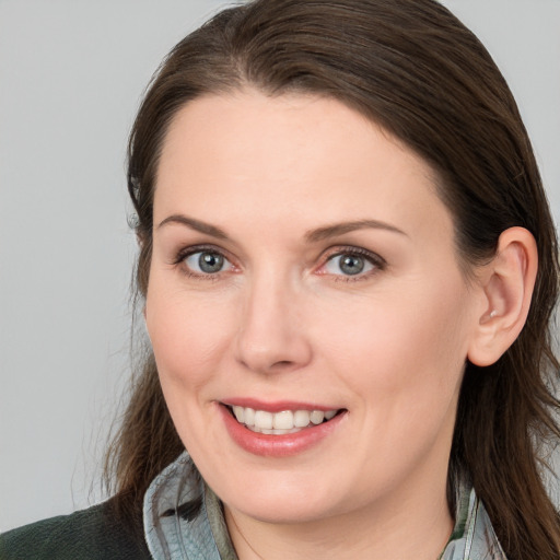 Joyful white young-adult female with medium  brown hair and grey eyes