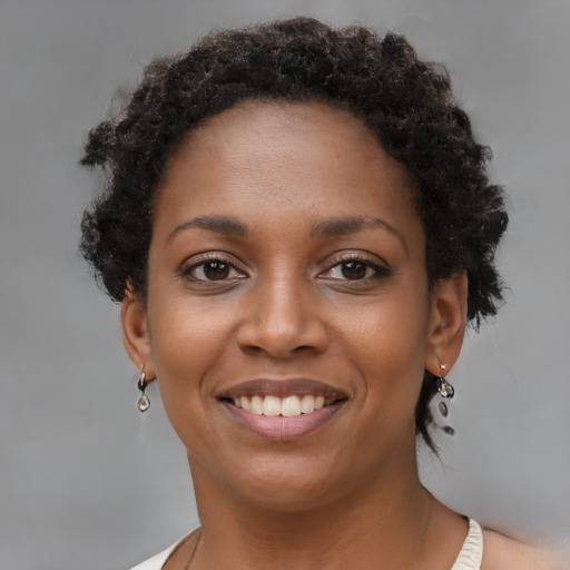 Joyful black young-adult female with short  brown hair and brown eyes