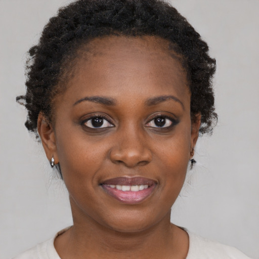 Joyful black young-adult female with short  brown hair and brown eyes