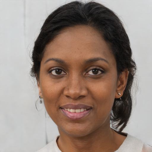 Joyful black adult female with medium  brown hair and brown eyes