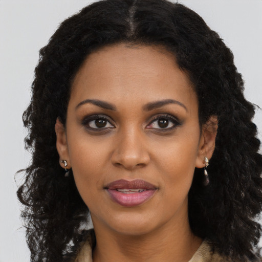 Joyful black young-adult female with long  brown hair and brown eyes