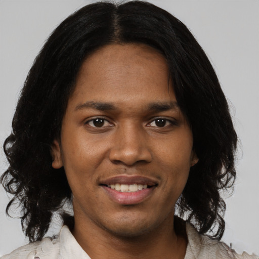 Joyful black young-adult male with medium  black hair and brown eyes