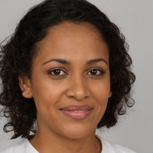 Joyful black young-adult female with medium  brown hair and brown eyes