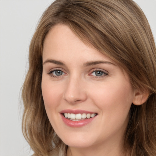 Joyful white young-adult female with long  brown hair and grey eyes