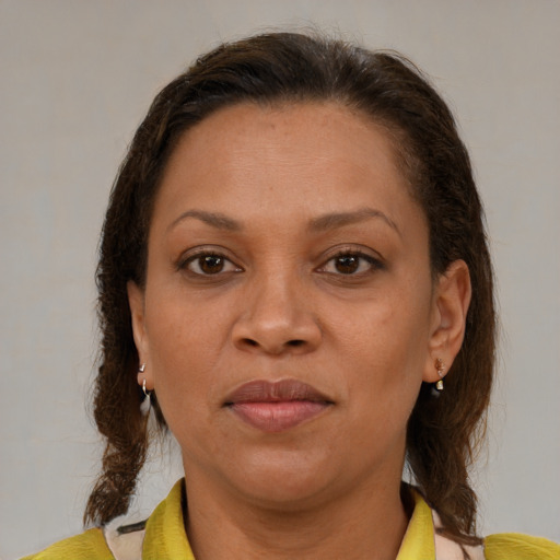 Joyful latino adult female with medium  brown hair and brown eyes