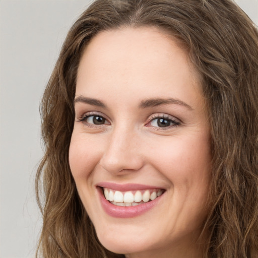 Joyful white young-adult female with long  brown hair and green eyes