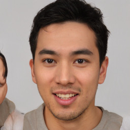 Joyful asian young-adult male with short  brown hair and brown eyes