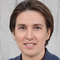 Joyful white adult female with medium  brown hair and grey eyes