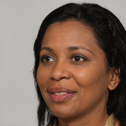 Joyful black adult female with long  black hair and brown eyes