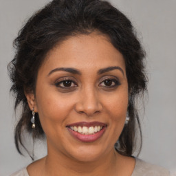 Joyful latino young-adult female with medium  brown hair and brown eyes