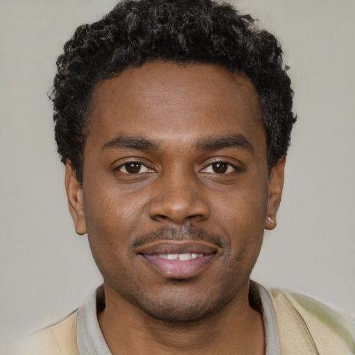 Joyful black young-adult male with short  black hair and brown eyes